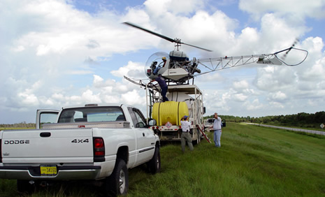 For large stands of trees, helicopters are used to apply herbicide. On a dike, this helicopter is filling its spray tanks.