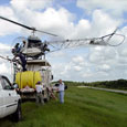 For large stands of trees, helicopters are used to apply herbicide. On a dike, this helicopter is filling its spray tanks.